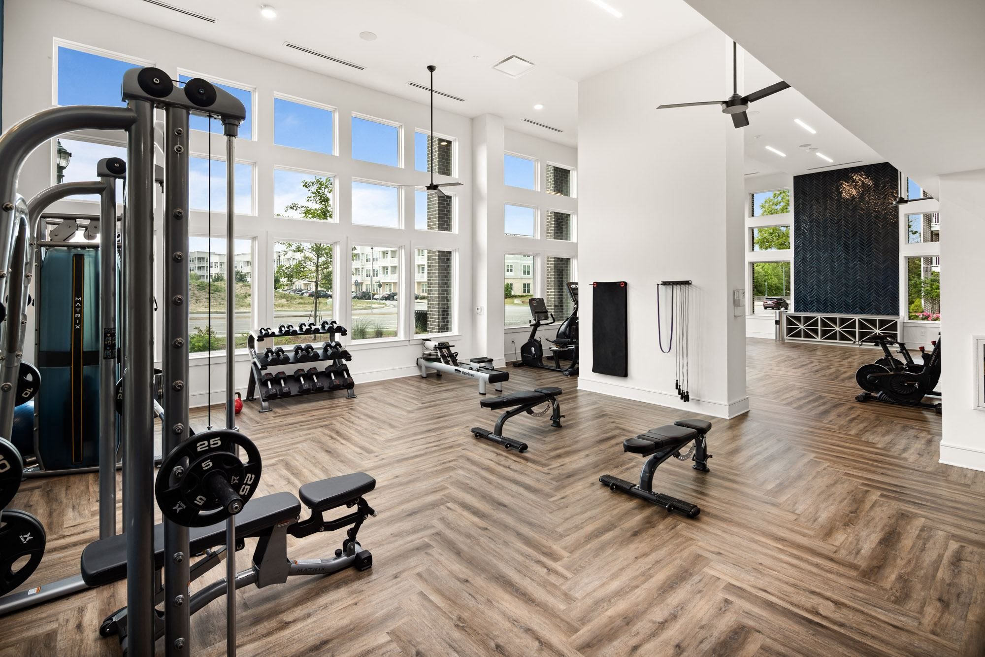 a gym with weights and exercise equipment and large windows